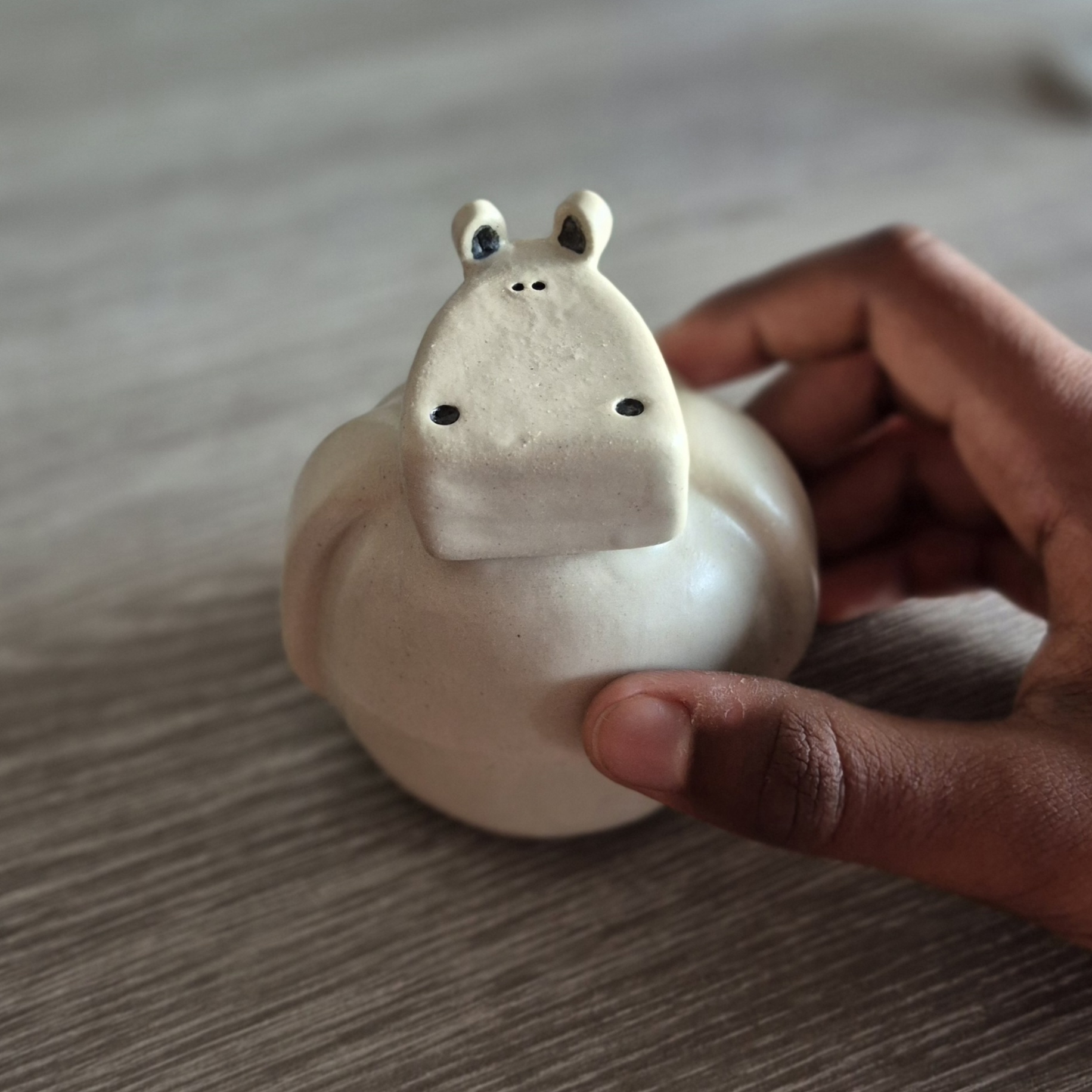 Petit vase hippopotame en céramique artisanale tenu dans une main